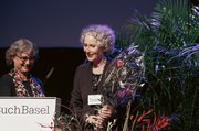 Anna-Katharina Schmid (Vorstand LiteraturBasel) übergibt Blumen an Katrin Eckert (Geschäftsleitung LiteraturBasel)