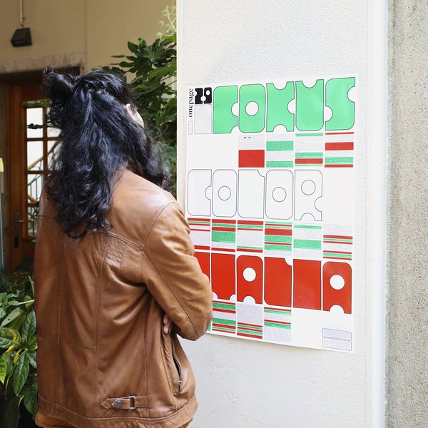 Eine Person steht vor dem Plakat "Fokus Color Italia"